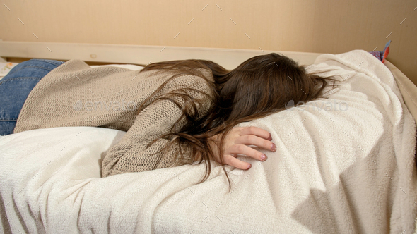 Crying Teenage Girl Jumping On Bed And Lying On Soft Pillow Stock Photo ...